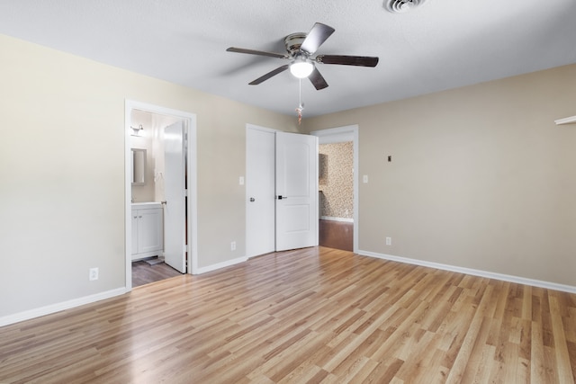 unfurnished bedroom with ceiling fan, light wood-type flooring, and connected bathroom