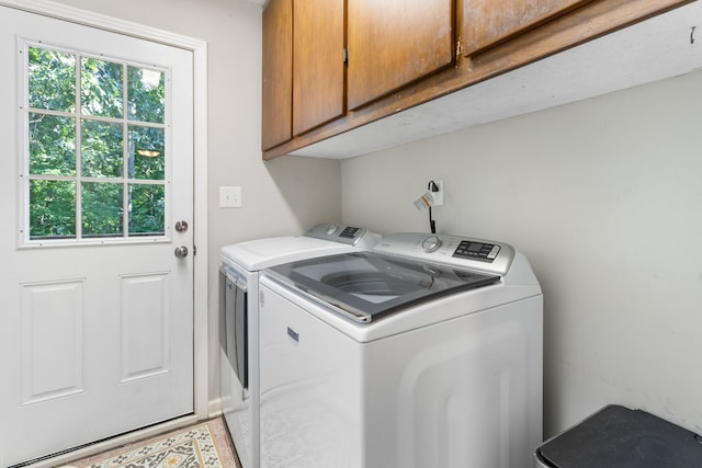 laundry area featuring washing machine and clothes dryer and cabinets