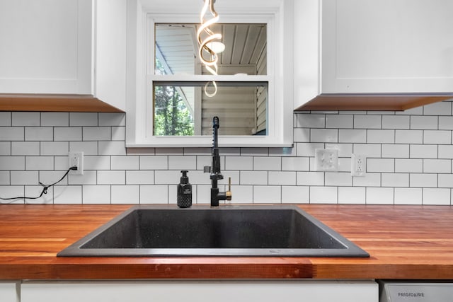 kitchen with sink, tasteful backsplash, and white cabinets