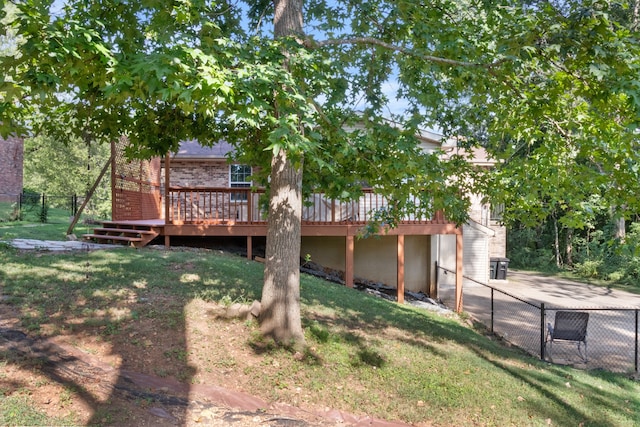 rear view of house with a wooden deck and a yard