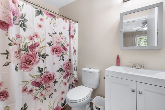 bathroom with ceiling fan, a textured ceiling, vanity, and toilet