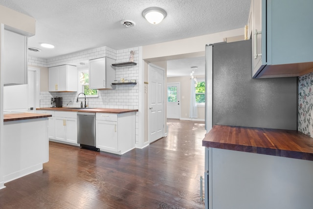 kitchen with backsplash, dark hardwood / wood-style floors, wood counters, dishwasher, and sink