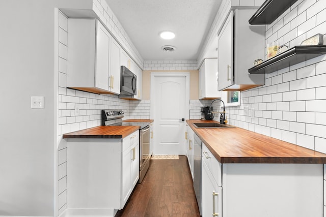 kitchen featuring sink, wood counters, dark wood-type flooring, tasteful backsplash, and stainless steel electric range oven