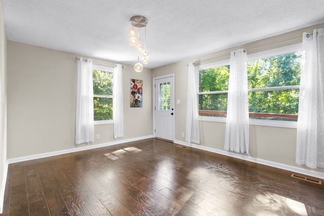 spare room featuring hardwood / wood-style flooring, plenty of natural light, and a textured ceiling