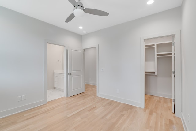 unfurnished bedroom with a walk in closet, light hardwood / wood-style flooring, ceiling fan, connected bathroom, and a closet