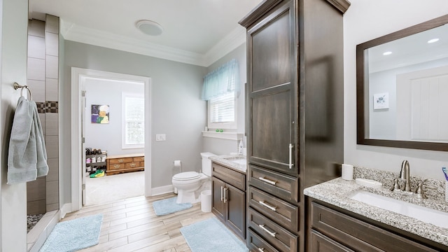 bathroom featuring a shower, toilet, crown molding, and vanity