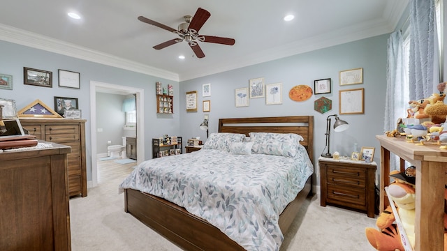 carpeted bedroom with ceiling fan, connected bathroom, and ornamental molding