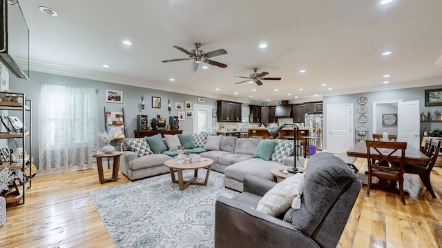 living room with light wood-type flooring, a wealth of natural light, and ceiling fan