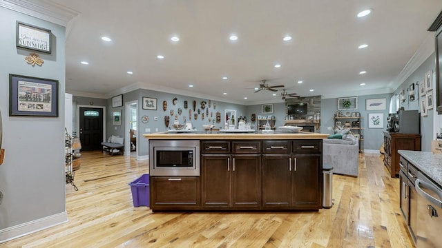 1019 Parker Rd, Kingston Springs, TN 37082 - kitchen featuring crown molding, open floor plan, light wood-type flooring, stainless steel microwave, and ceiling fan