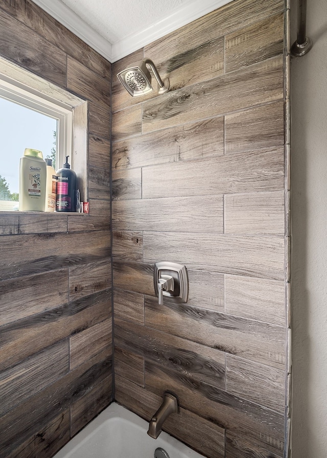 bathroom with tiled shower / bath, ornamental molding, and a textured ceiling