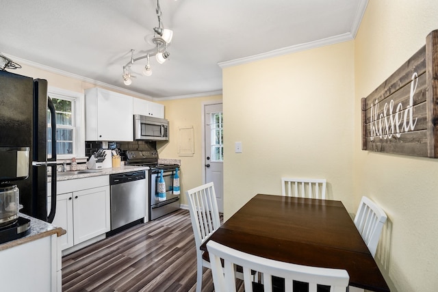 kitchen featuring appliances with stainless steel finishes, rail lighting, dark hardwood / wood-style floors, tasteful backsplash, and white cabinets