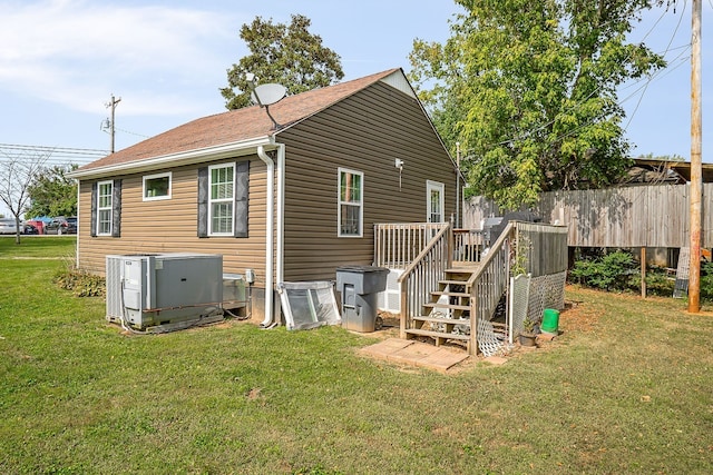 back of property featuring a deck, central AC, and a yard