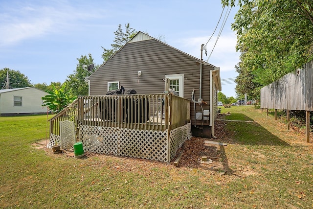 back of house featuring a wooden deck and a lawn