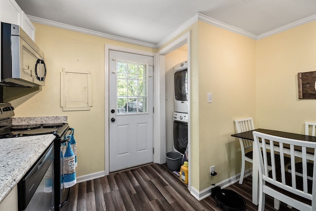 kitchen with dark wood-type flooring, stainless steel appliances, stacked washer / dryer, crown molding, and white cabinets