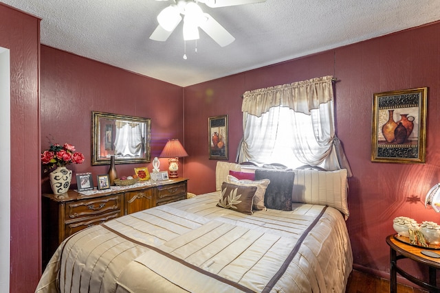 bedroom with a textured ceiling, ceiling fan, and hardwood / wood-style floors