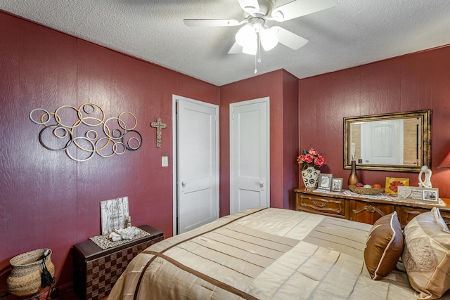 bedroom with ceiling fan and a textured ceiling