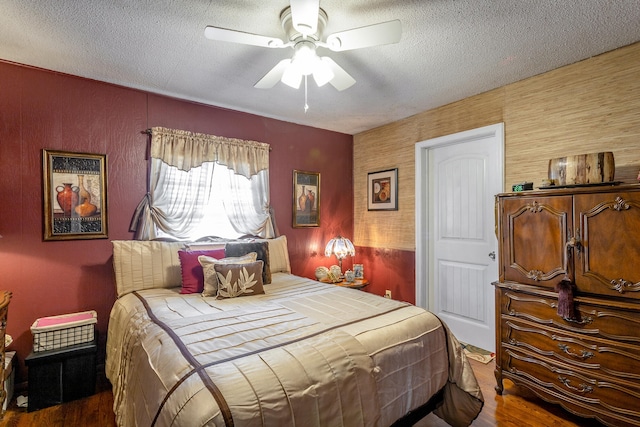 bedroom featuring a textured ceiling, ceiling fan, and hardwood / wood-style floors