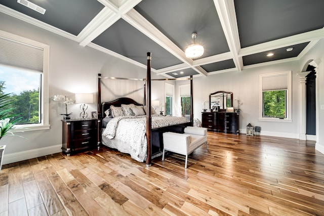 bedroom featuring hardwood / wood-style floors, beam ceiling, coffered ceiling, and multiple windows