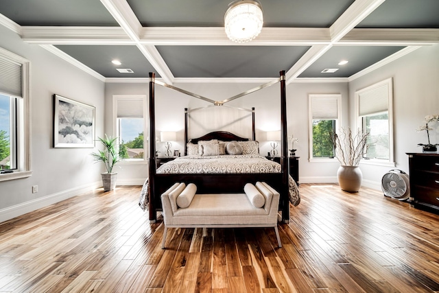 bedroom featuring coffered ceiling, multiple windows, and wood finished floors