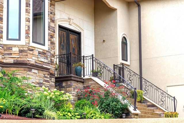 view of exterior entry with stone siding and stucco siding