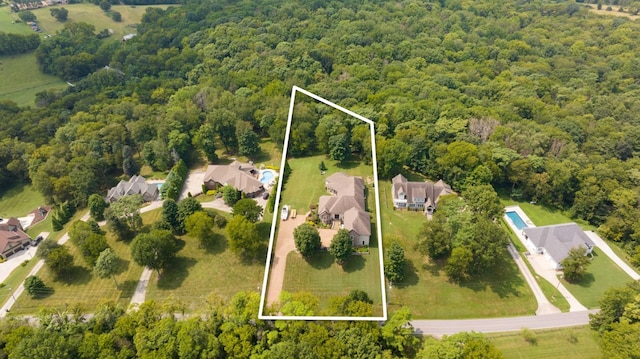 birds eye view of property featuring a residential view and a wooded view