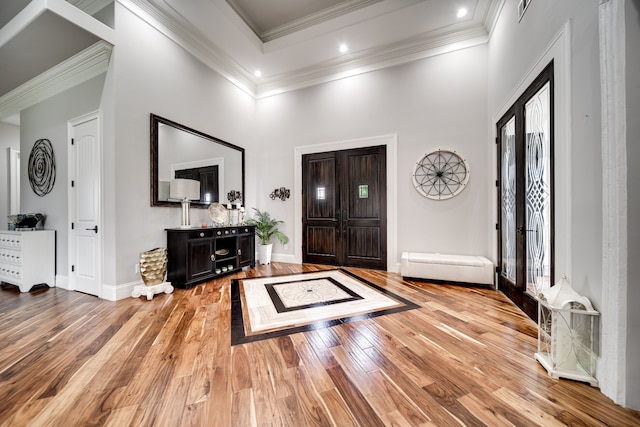 entrance foyer with a wealth of natural light, light hardwood / wood-style floors, and ornamental molding