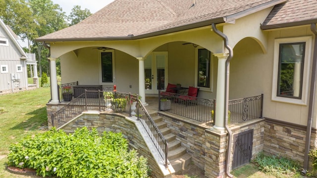 exterior space with french doors, stucco siding, a shingled roof, a lawn, and a ceiling fan