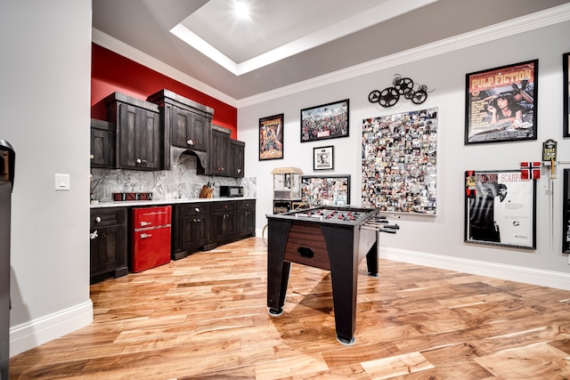 kitchen with decorative backsplash, light hardwood / wood-style floors, dark brown cabinetry, and ornamental molding