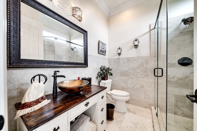 bathroom with toilet, vanity, tile walls, crown molding, and a shower with shower door