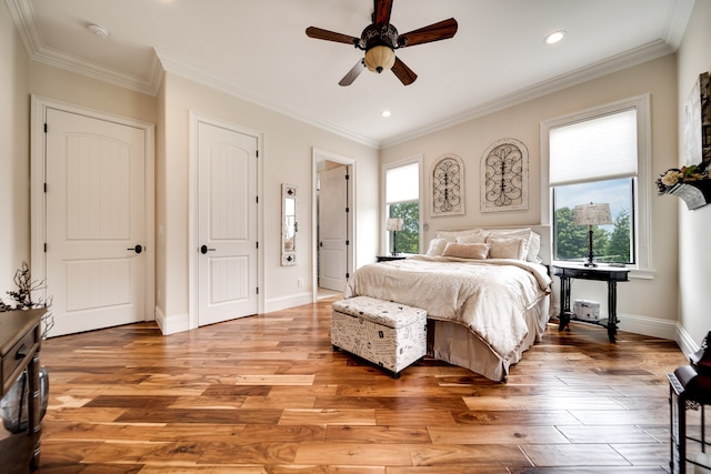 bedroom with ceiling fan, multiple windows, crown molding, and hardwood / wood-style flooring