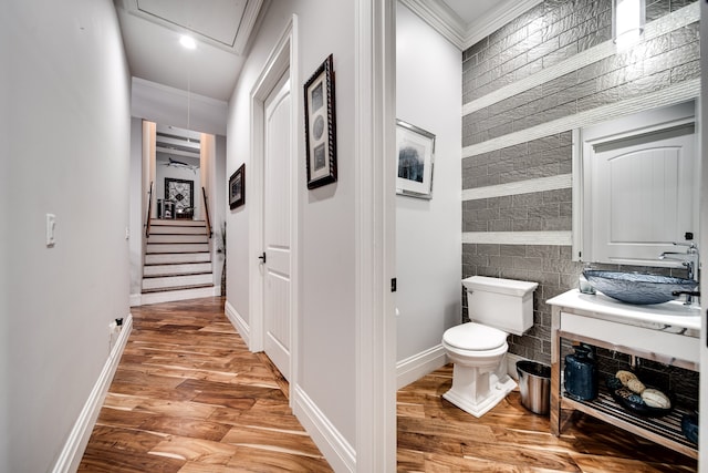 bathroom featuring toilet, vanity, wood-type flooring, tile walls, and crown molding