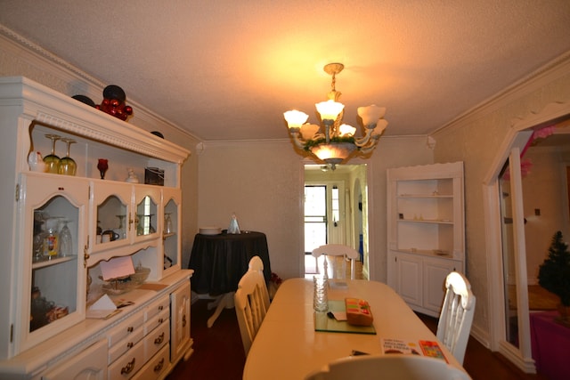 dining room featuring a textured ceiling, ornamental molding, and an inviting chandelier