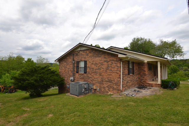 back of house with a lawn and cooling unit