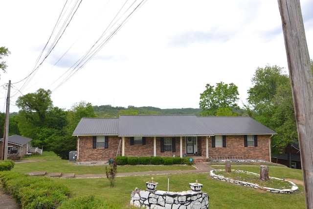 630 Marietta St, Pulaski, TN 38478 - ranch-style house featuring brick siding, a front lawn, covered porch, and a metal roof