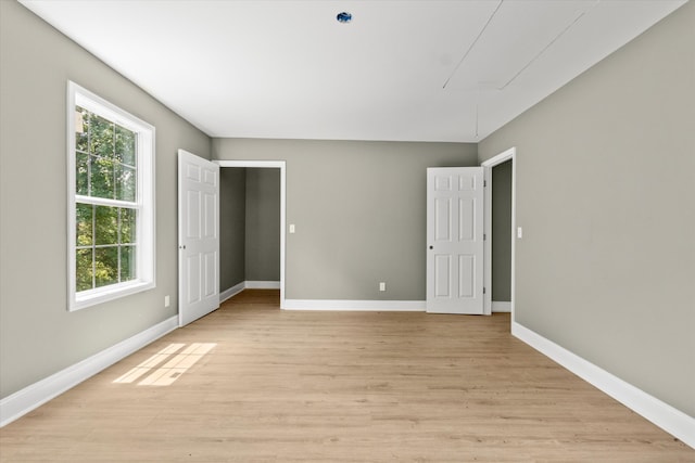 empty room with light hardwood / wood-style flooring and a healthy amount of sunlight