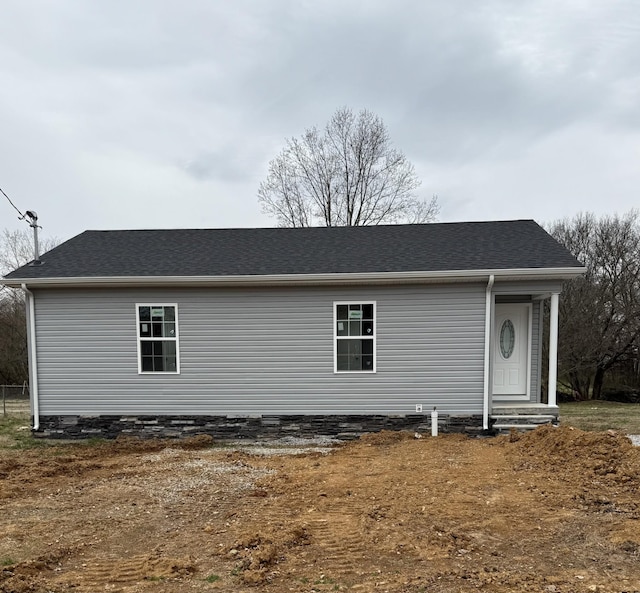 rear view of property with roof with shingles