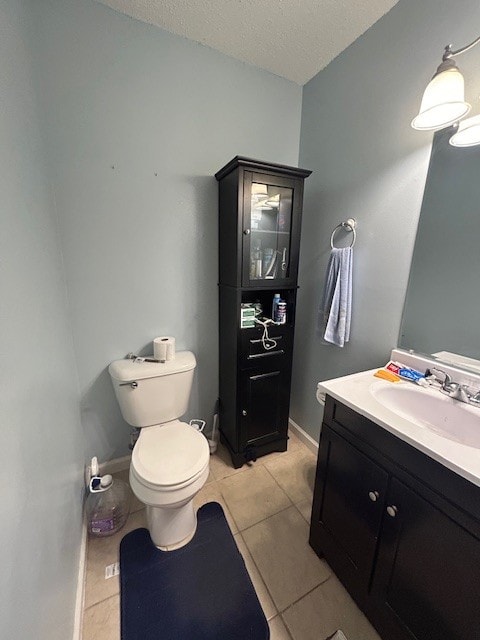 bathroom featuring tile patterned floors, toilet, a textured ceiling, and vanity