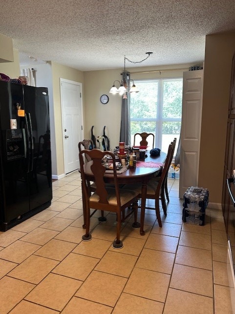 dining room featuring a notable chandelier, a textured ceiling, and light tile patterned floors