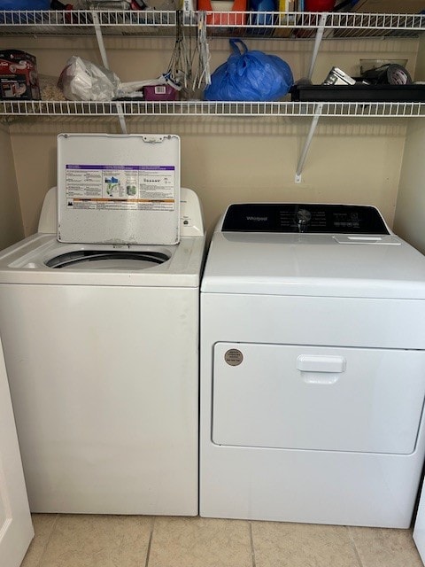 laundry room with light tile patterned floors and separate washer and dryer