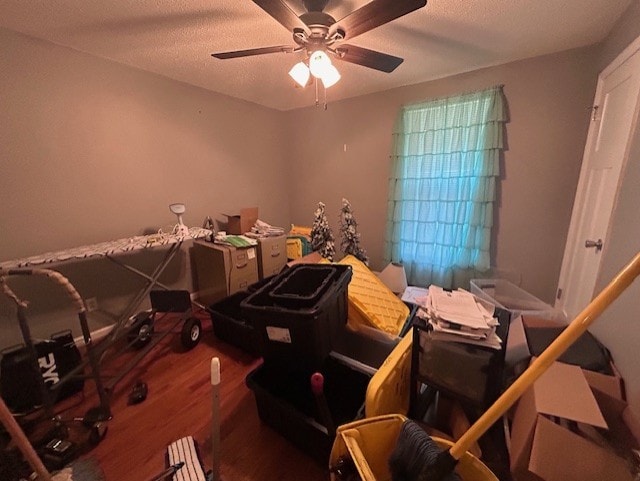 miscellaneous room featuring hardwood / wood-style floors, ceiling fan, and a textured ceiling