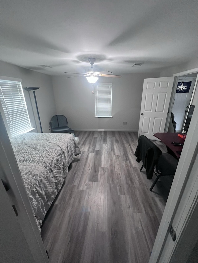 bedroom featuring visible vents, ceiling fan, baseboards, and wood finished floors