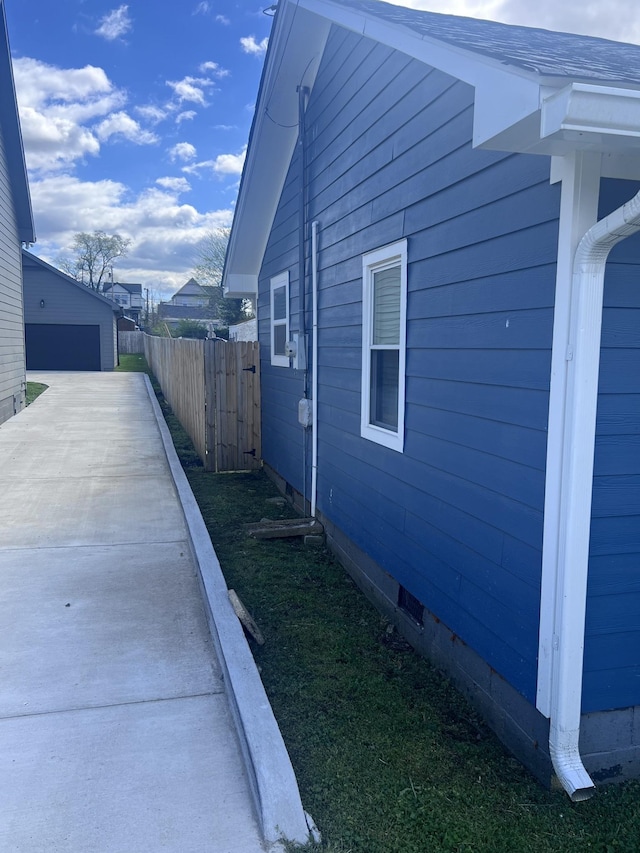 view of home's exterior with crawl space, fence, and an outdoor structure