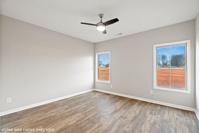 empty room with ceiling fan and hardwood / wood-style flooring