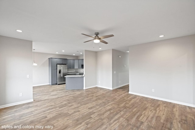 unfurnished living room featuring light hardwood / wood-style flooring and ceiling fan