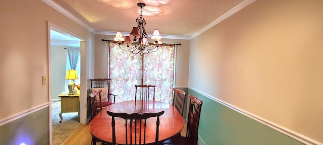 dining area featuring carpet flooring, ornamental molding, a chandelier, and a textured ceiling