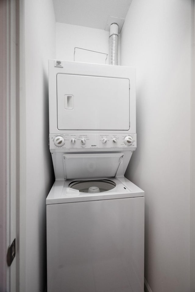 washroom featuring laundry area and stacked washer / dryer