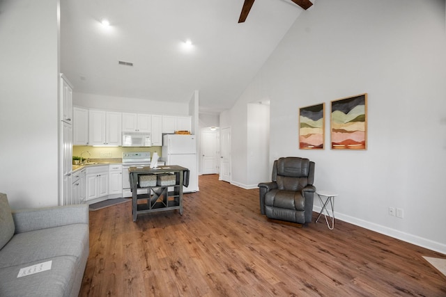 living room featuring ceiling fan, high vaulted ceiling, wood finished floors, visible vents, and baseboards