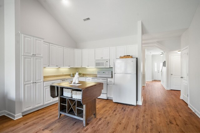 kitchen featuring white appliances, white cabinets, a center island, and light hardwood / wood-style flooring