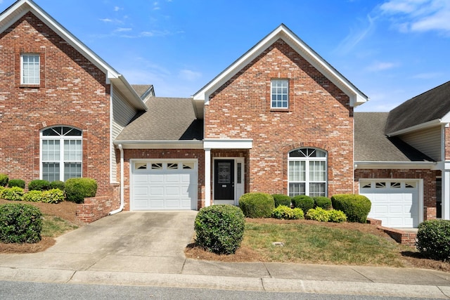 traditional-style house featuring concrete driveway, brick siding, an attached garage, and a shingled roof