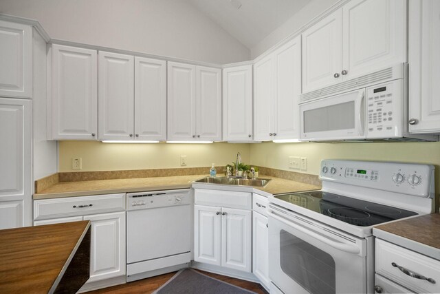 kitchen with hardwood / wood-style flooring, white cabinetry, lofted ceiling, and white appliances